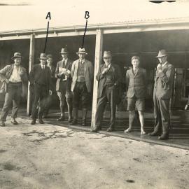 Men standing in a milking shed