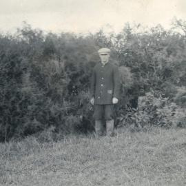 Man standing before bushes